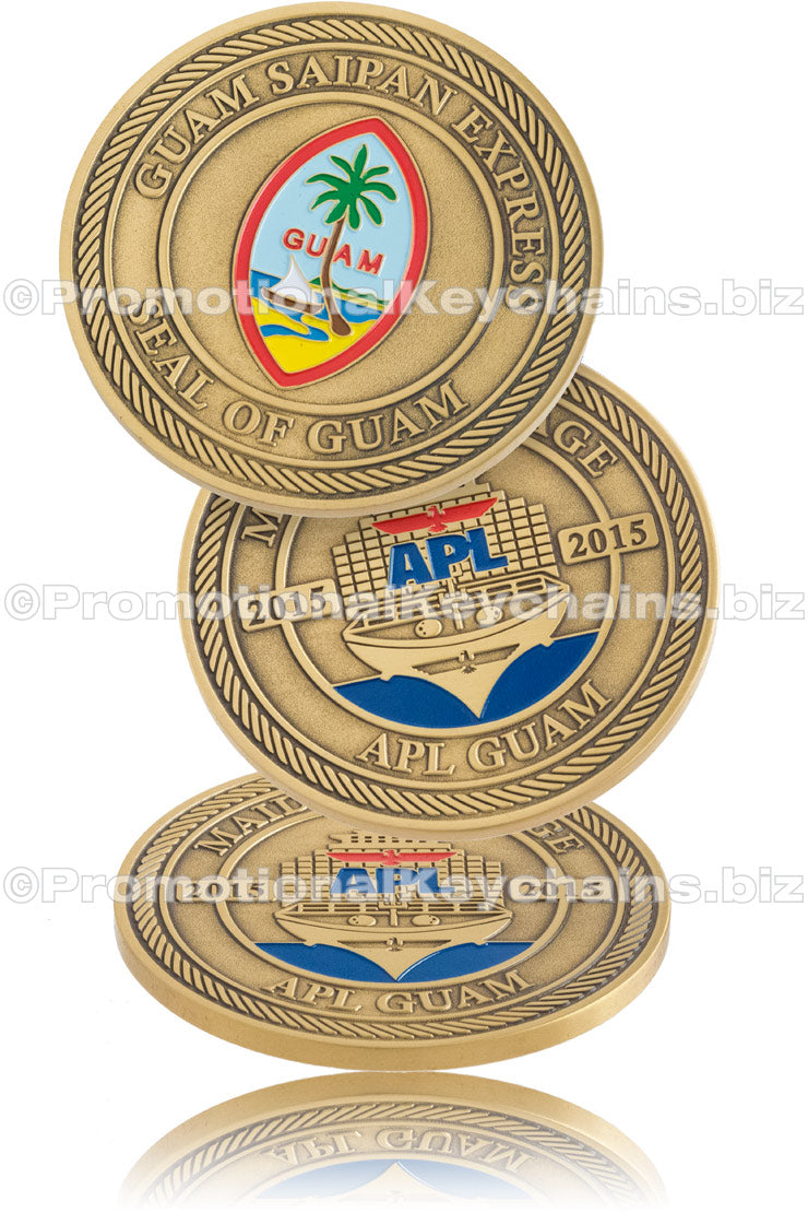 Three angles of an antiqued brass coin, featuring a multicolor Guam seal on the front and an APL ship design on the back, commemorating "Guam Saipan Express".