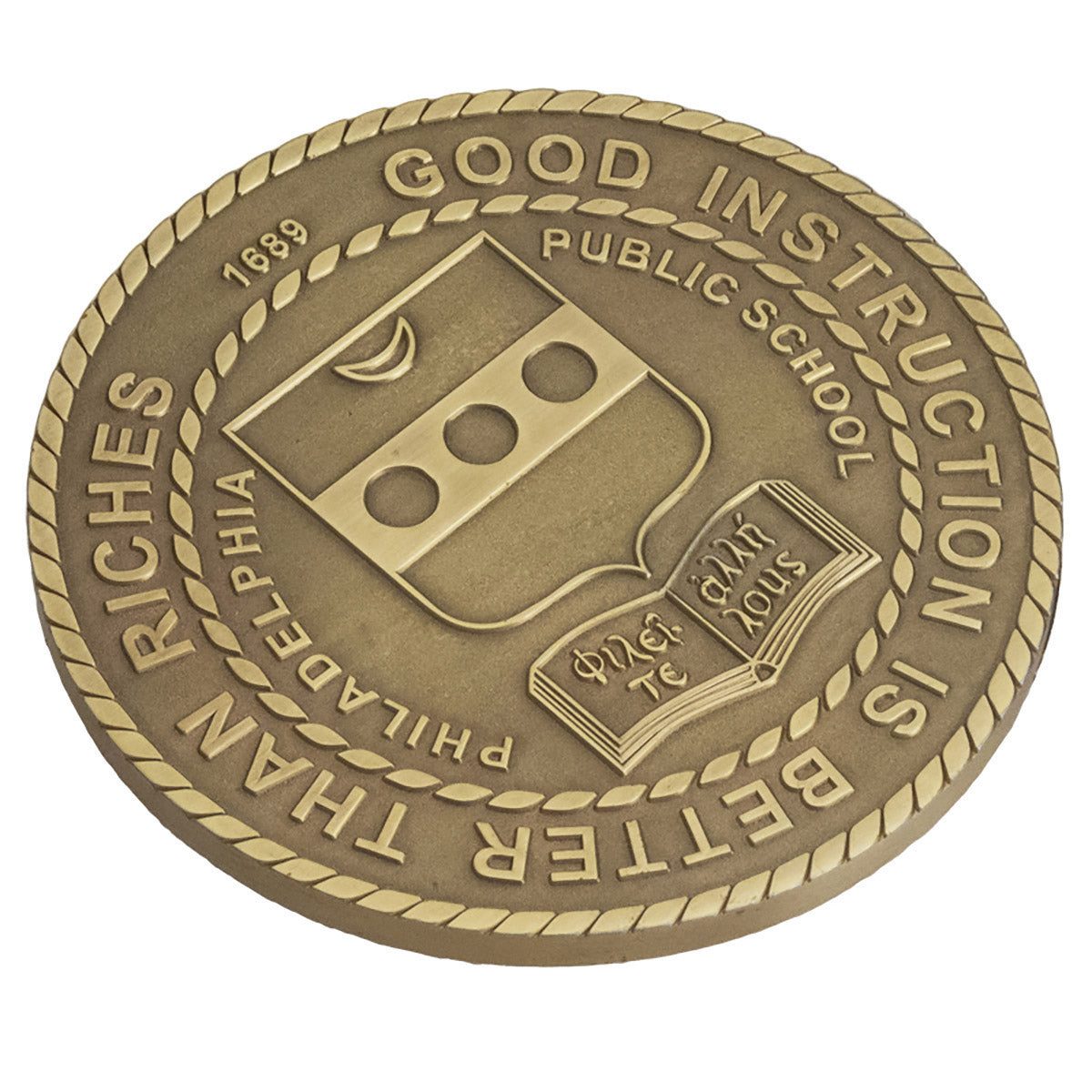 An antiqued brass coaster featuring a Philadelphia Public School logo, surrounded by a rope border.