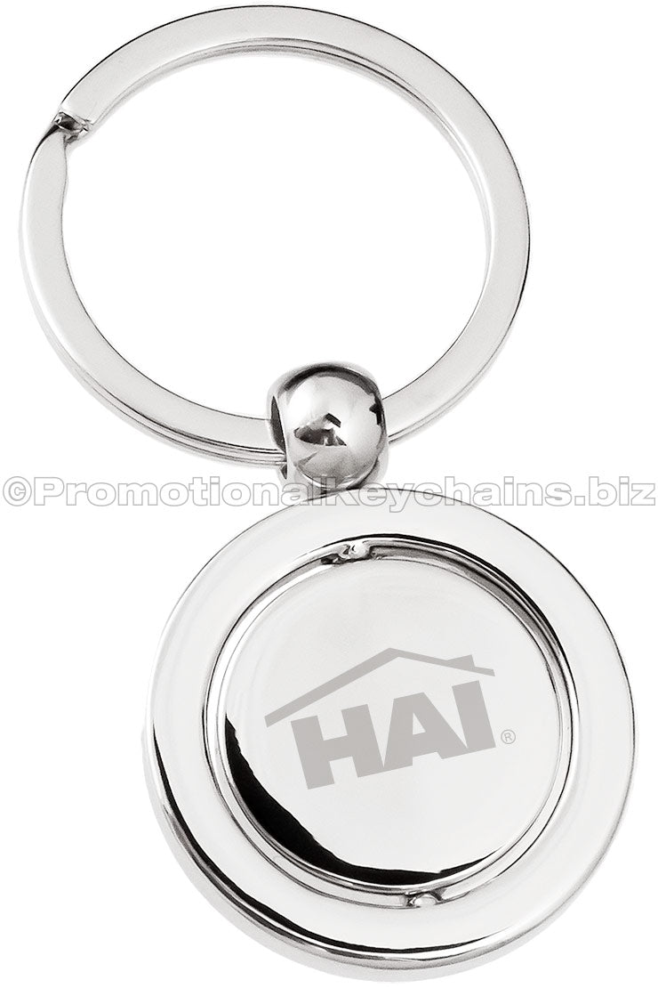 A polished keychain featuring a round spinning disc with an engraved logo displayed prominently in the center.