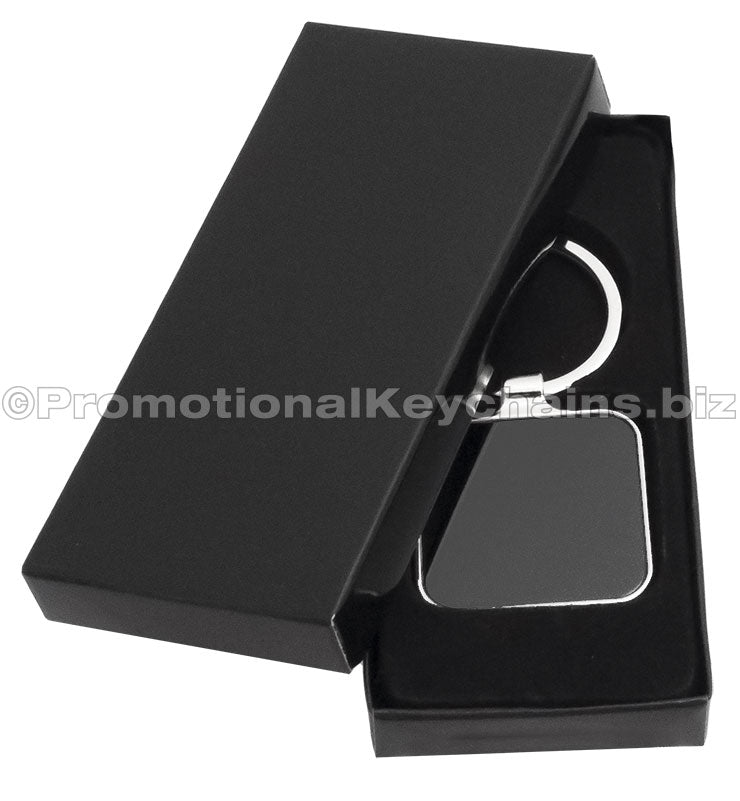 A polished metal keychain featuring a square black background displayed in a black gift box.