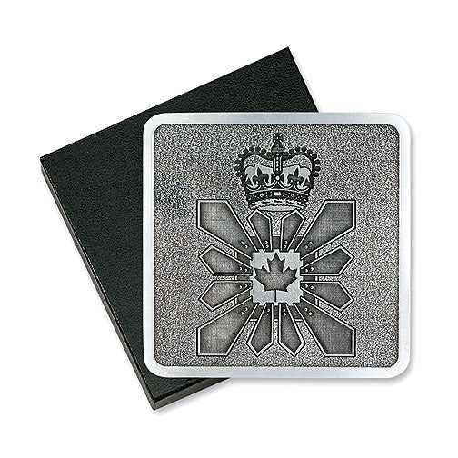 A square solid pewter coaster featuring a crown and a stylized maple leaf design resting on a black presentation box.