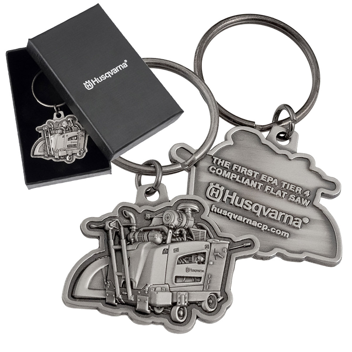 Both sides of an antiqued nickel keychain featuring a detailed, 3-dimensional flat saw design and text embossed on the back side. There is also an image of the same keychain inside of a black gift box, and the lid of the box has a customized silver imprint.