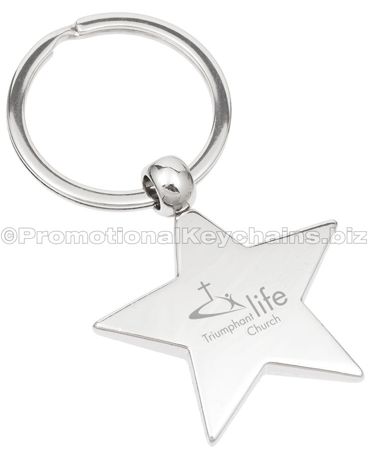 A polished metal star-shaped keychain with "Triumphant Life Church" engraved in the center.