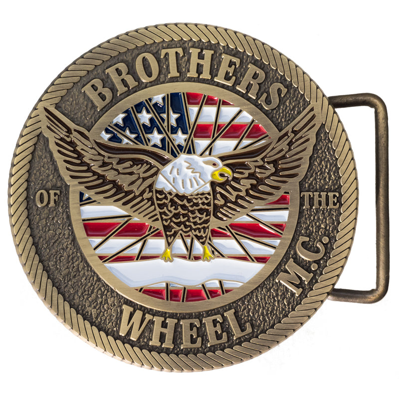 A detailed belt buckle featuring an emblem with a bald eagle in front of an American flag, showcasing intricate detail and a rope border.