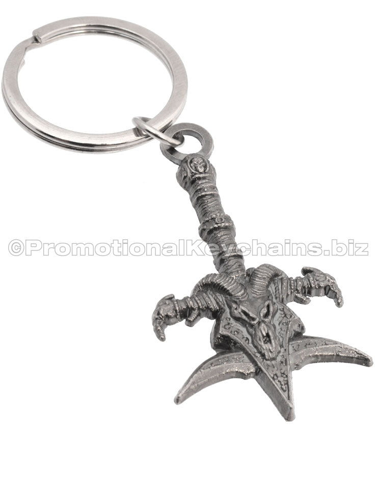 A detailed metal keychain shaped like a ornate mace with a skull, ram horns, and a decorative handle.