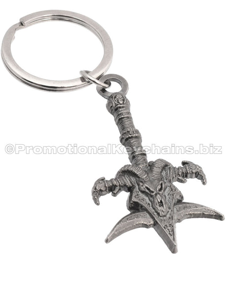 A detailed metal keychain shaped like a ornate mace with a skull, ram horns, and a decorative handle.
