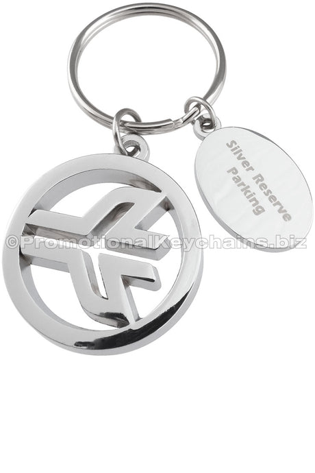 A polished nickel keychain featuring a plane logo centered in a circle with an engraved oval medallion attached to the same keyring.