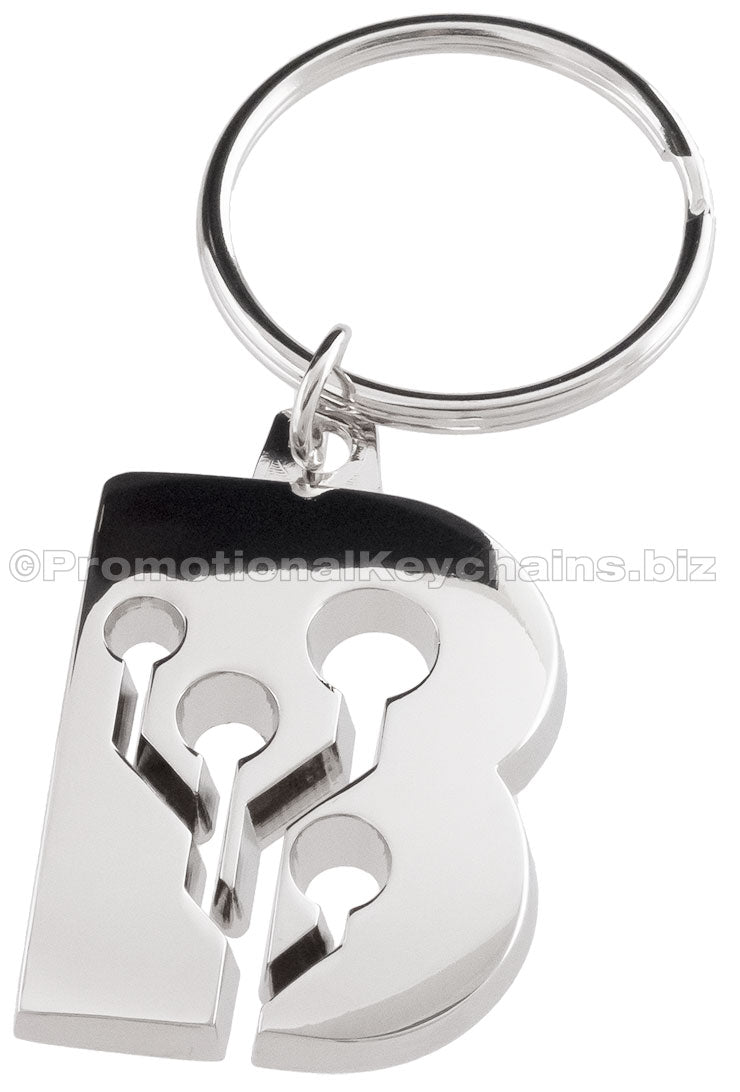 A shiny metal keychain plated in polished nickel molded to the shape of the letter "B," featuring a circuit design with holes and connectors.
