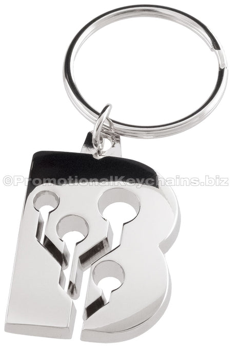 A shiny metal keychain plated in polished nickel molded to the shape of the letter "B," featuring a circuit design with holes and connectors.