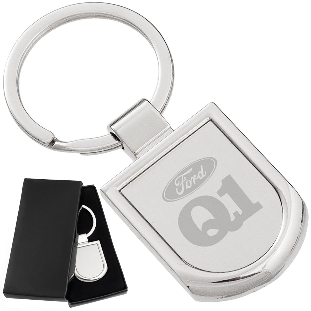 There are two images. On the left, a polished silver keychain featuring a badge-shaped pendant displayed in a black gift box. On the right is the same keychain with a logo clearly engraved in the center.