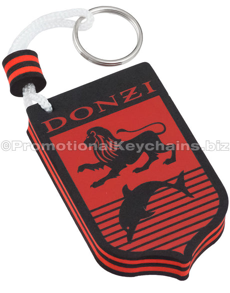 A red and black floating foam keychain with a lion and dolphin design, featuring the text "DONZI" at the top. It is contained in the shape of a shield.