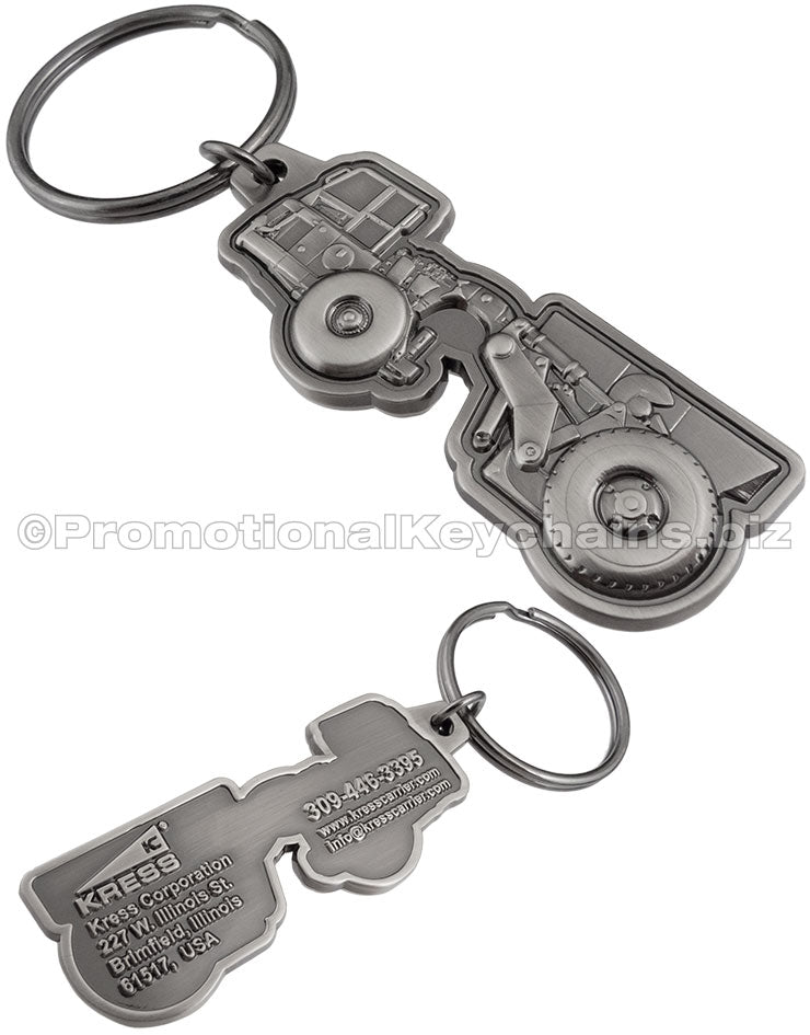 Both sides of an antiqued nickel keychain with a 3-dimensional tractor design on the front and the Kress Corporation's logo and contact info on the reverse side.