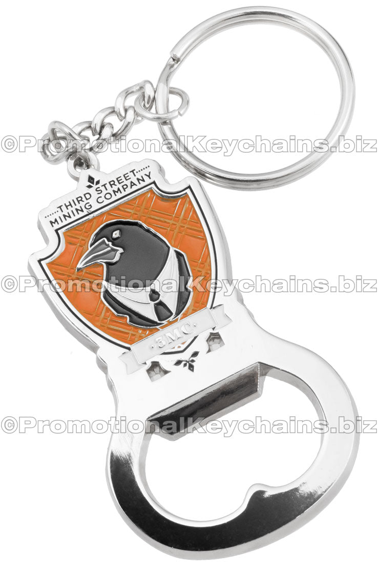 Custom Die Cast 3D/2D Bottle Opener Keychains. Polished silver nickel and soft enamel. Design shaped like a shield with a black raven in the center.