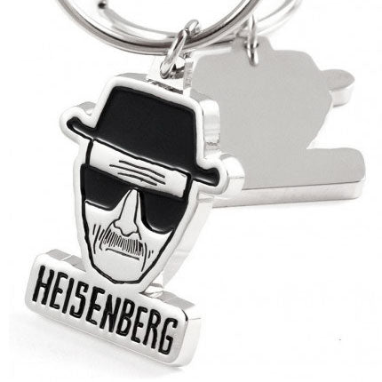 The front and back of polished nickel keychain featuring a stylized head with a hat and the name "HEISENBERG" in black enamel color underneath. The back side has a smooth, shiny finish.