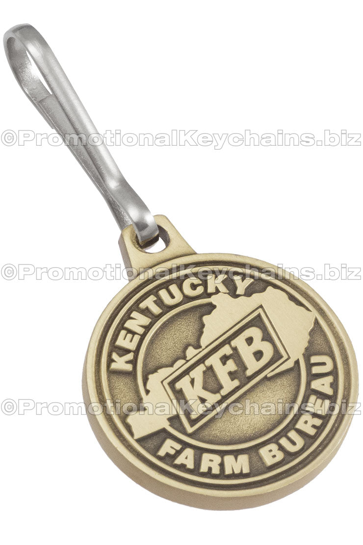 A circular, antiqued brass zipper pull with "Kentucky Farm Bureau" branding.