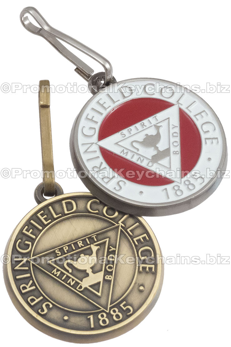 Two antiqued zipper pulls featuring Springfield College's emblem: one in white and red and plated in nickel, the other without color and plated in brass.