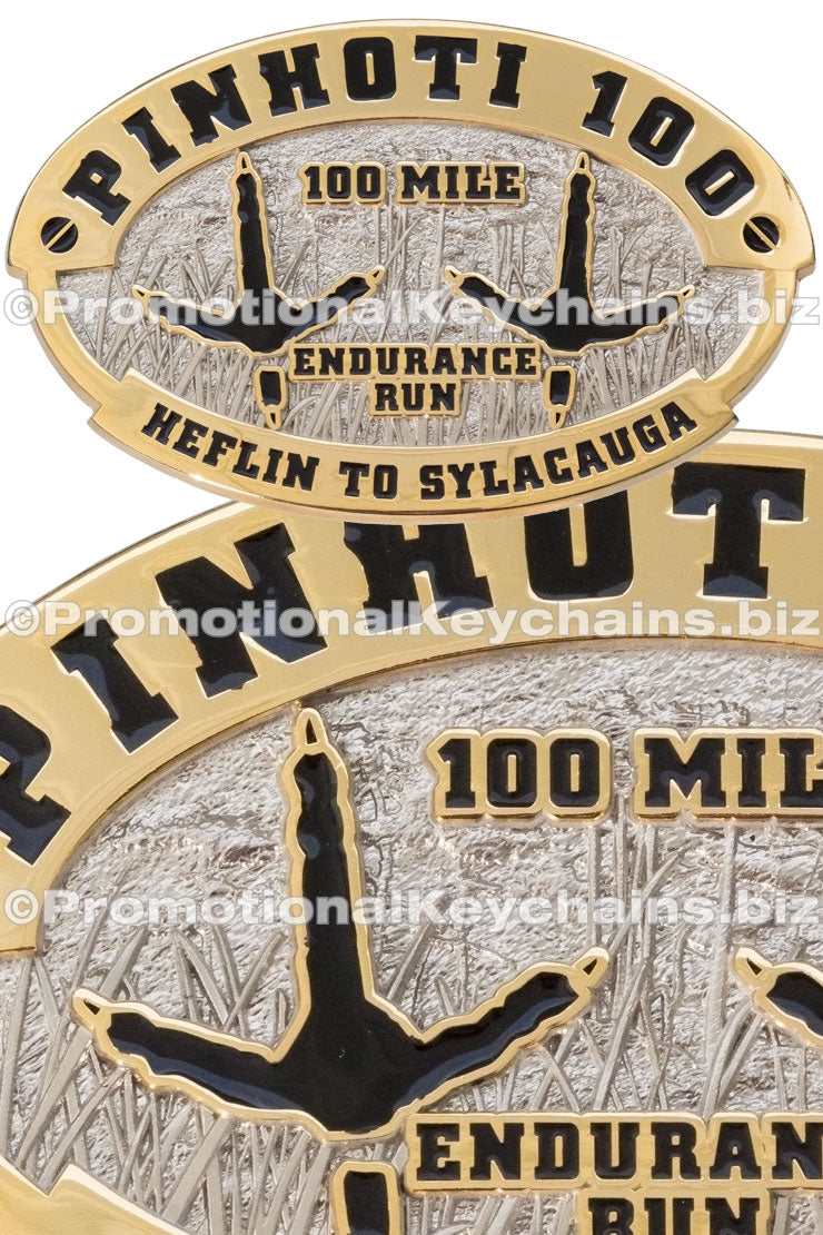 Two images of the same belt buckle overlapped onto one another, dual-plated in nickel and gold with the outline of two avian footprints in the center.