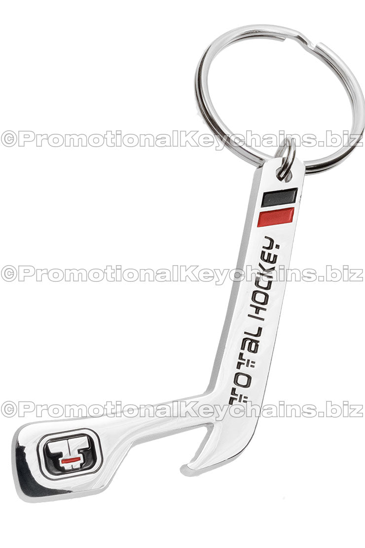 Custom shaped bottle opener keychain in the shape of a hockey stick. Hook at the end of the hockey stick and design uses black and red enamels.