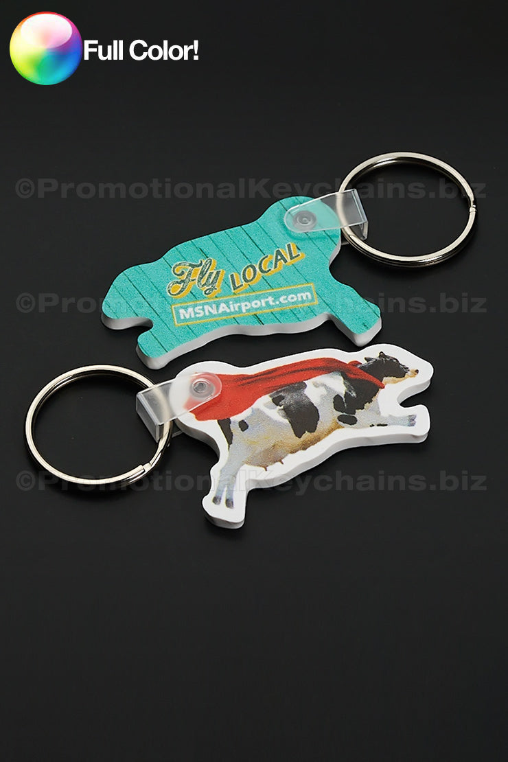 Custom Shaped Vinyl Keychains in Full Color of a cow wearing a red cape and FLY LOCAL on the reverse side in yellow and blue.