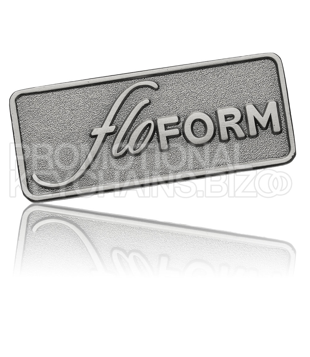 A rectangular antiqued nickel plate featuring the embossed logo for "floFORM" in the center on a sandblasted background.