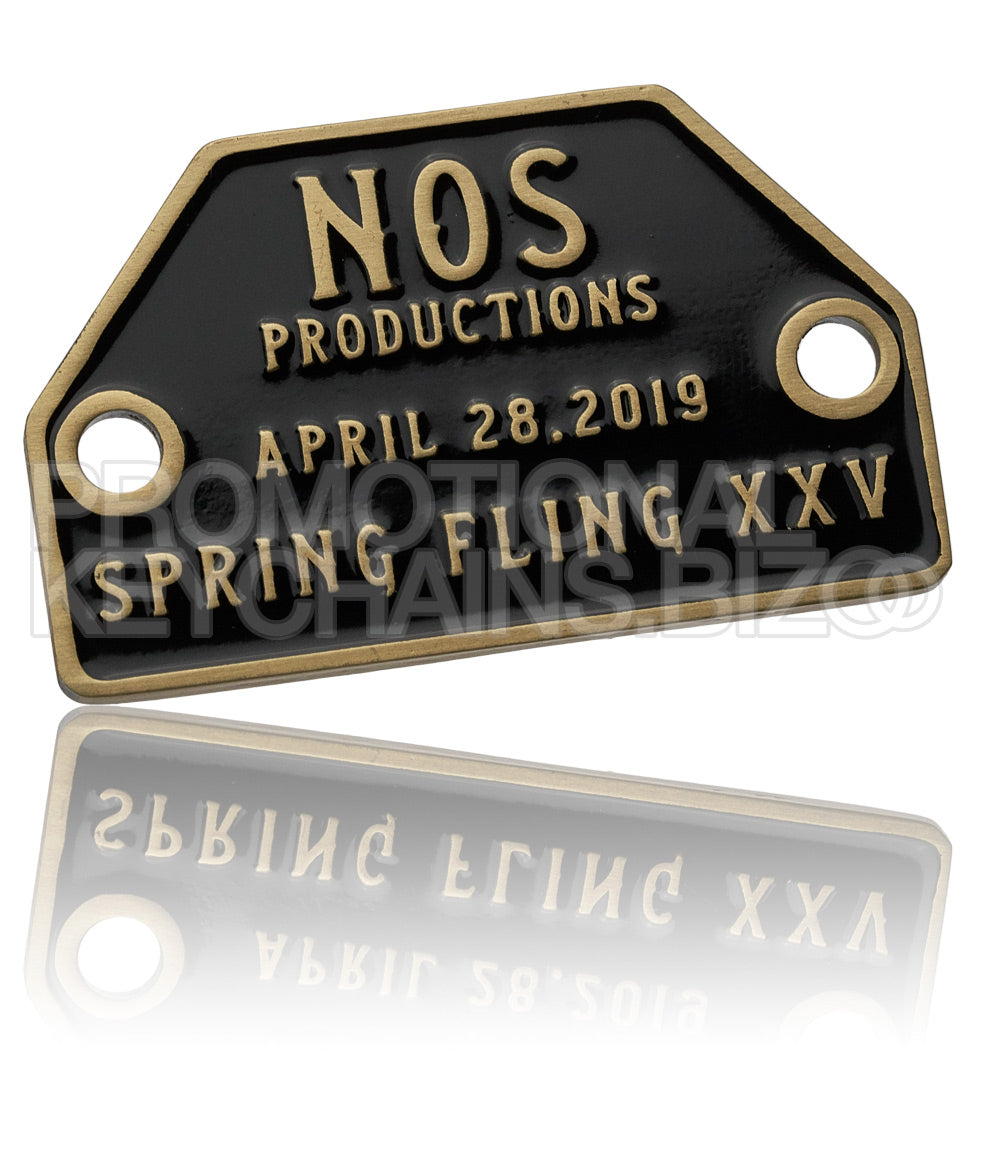 An antiqued brass metal plate with a black enamel background. There is a rivet hole on each side, with brass text raised above the black enamel color.