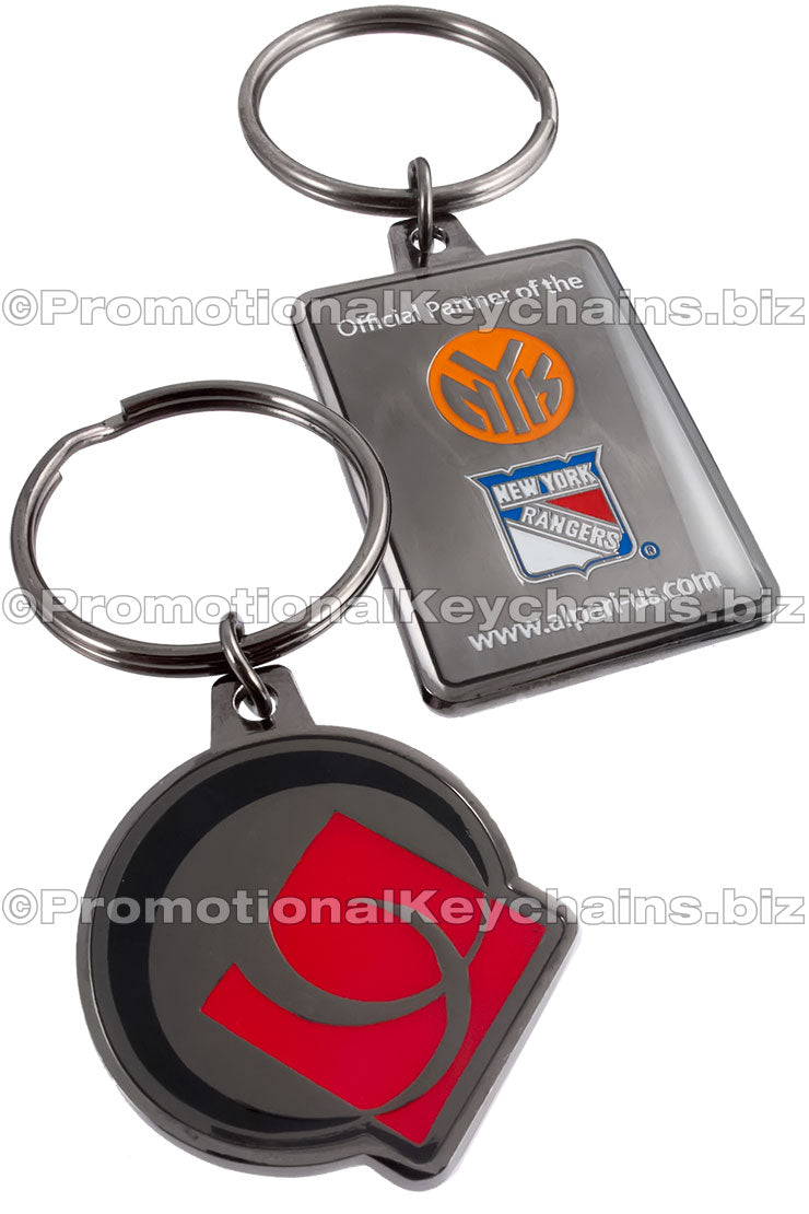 Two different polished black nickel keychains, one featuring various New York sports logos, and the other with an Ottawa Senators emblem in black and red enamel color.