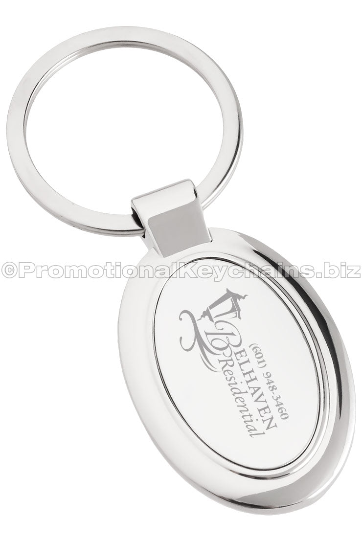 A polished metal ovular keychain featuring the logo for Belhaven Residential.
