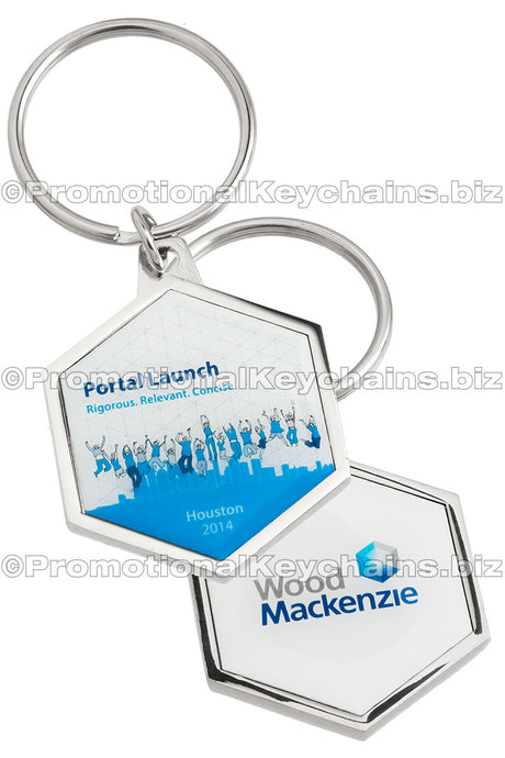 Both sides of an octagonal, polished nickel keychain with a full-color imprint on either side, both of which have blue and white color motifs and graphics with the Wood Mackenzie logo featured on the back.