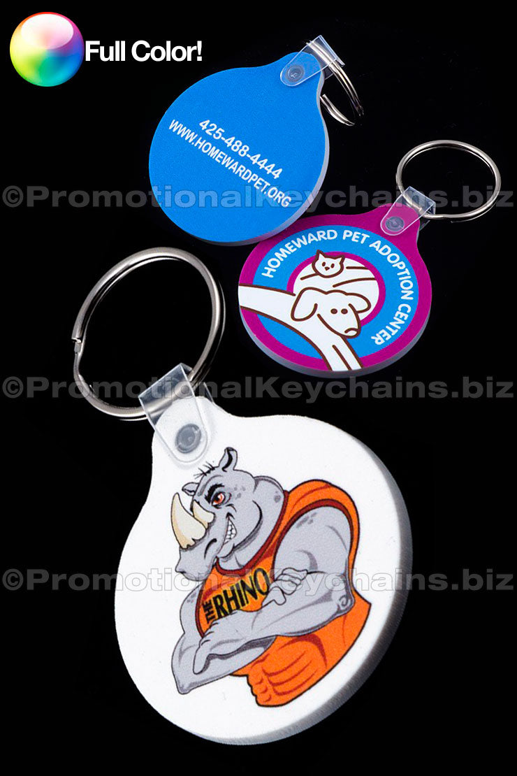 A collection of round vinyl keychains with a tab, featuring various full-color imprints including a cat and dog design and a rhino in a tank top.