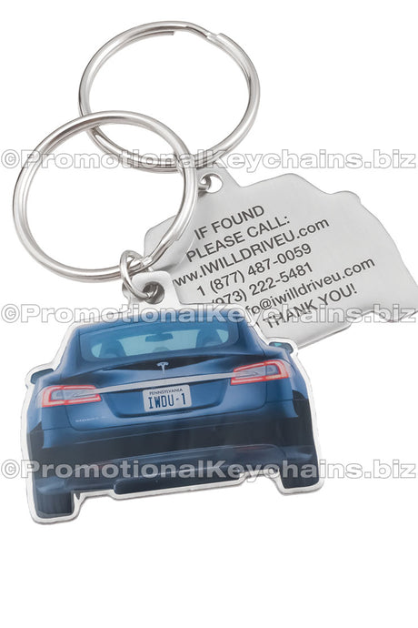 Two sides of a car-shaped stainless steel keychain, featuring a blue Tesla car image with a license plate "IWDU-1" on one side and contact information printed in black on the other.