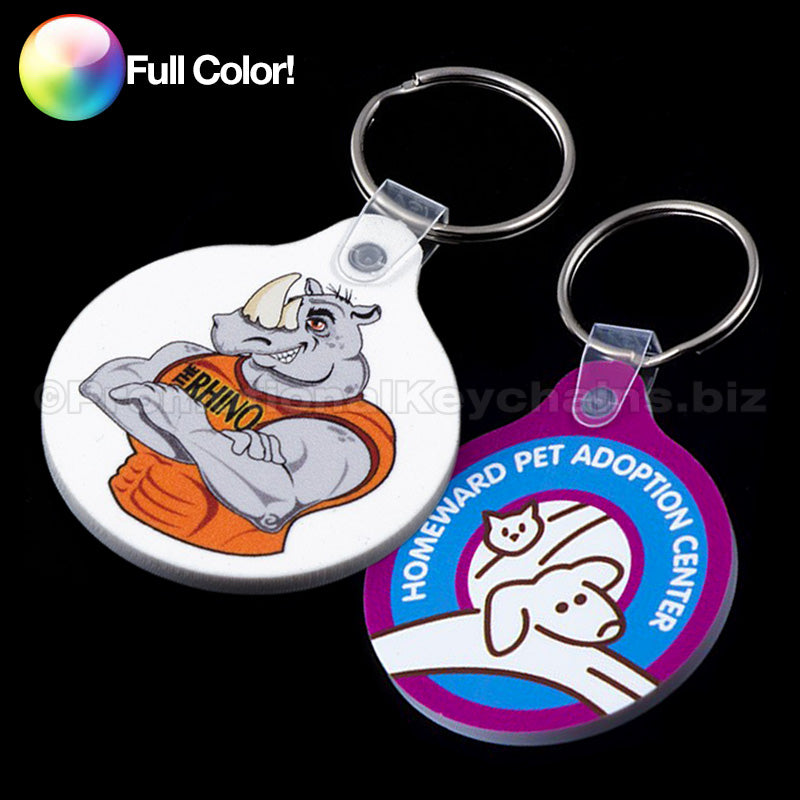A collection of round vinyl keychains with a tab, featuring various full-color imprints including a cat and dog design and a rhino in a tank top.