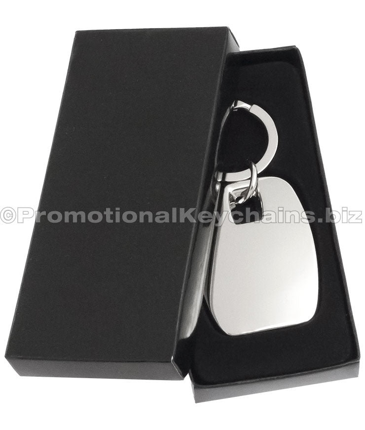 A polished metal rectangular keychain displayed in a black gift box.