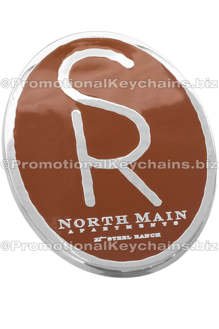 A polished nickel coaster with the logo for North Main Apartments in the center with a brown enamel color background.