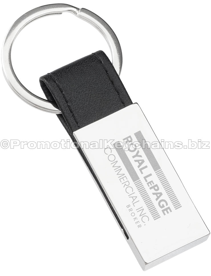A polished rectangular keychain with a black leather strap featuring the Royal LePage Commercial Inc. logo engraved in the center.