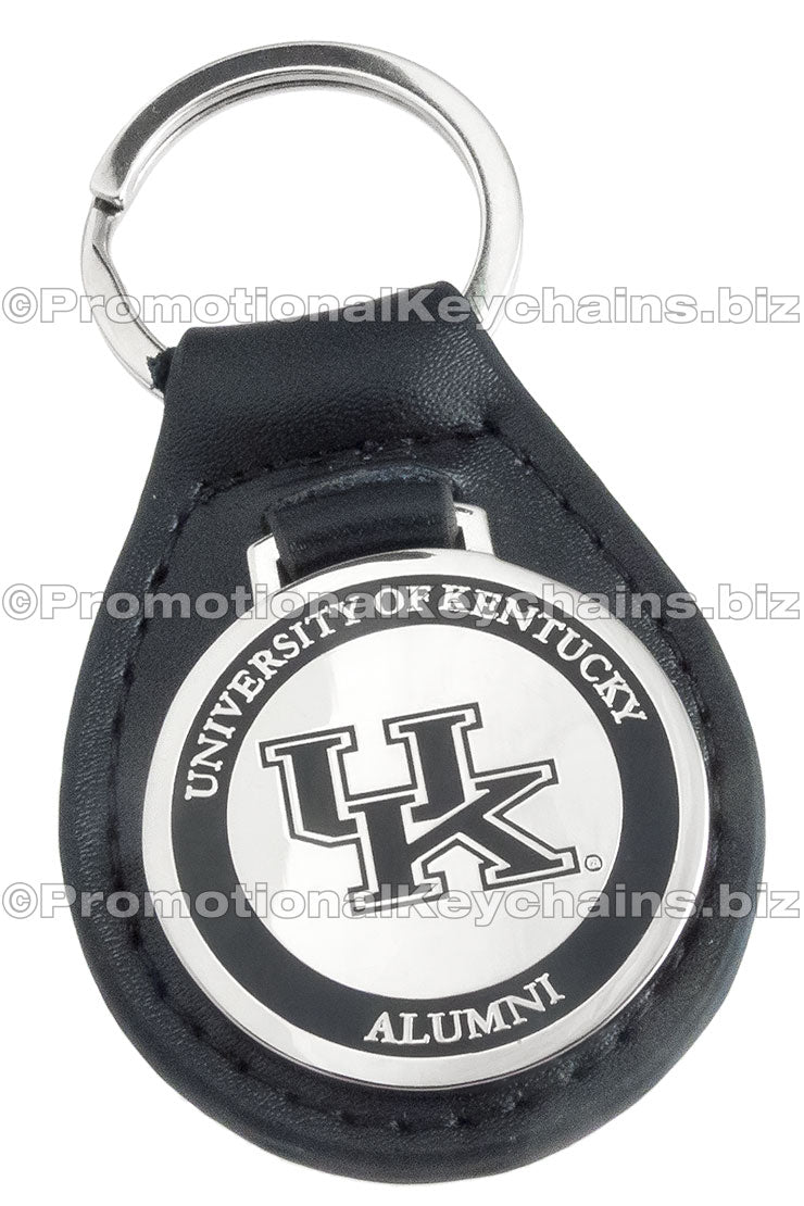 A black leather fob keychain with a polished nickel medallion attached, featuring a University of Kentucky Alumni design with a black enamel outer ring.