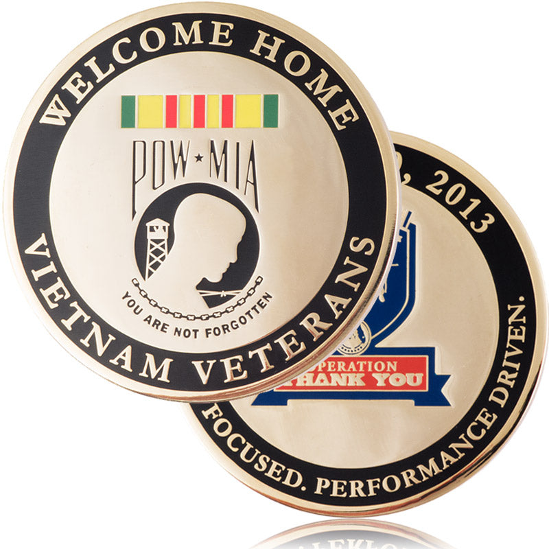 A commemorative coin for Vietnam Veterans, plated in polished brass with a black enamel color ring around the outer border, featuring "Welcome Home," the POW*MIA insignia, and various other verbiage honoring their service.