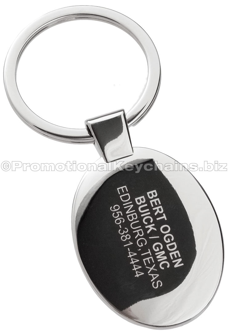 The back of a polished metal ovular keychain engraved with contact information.