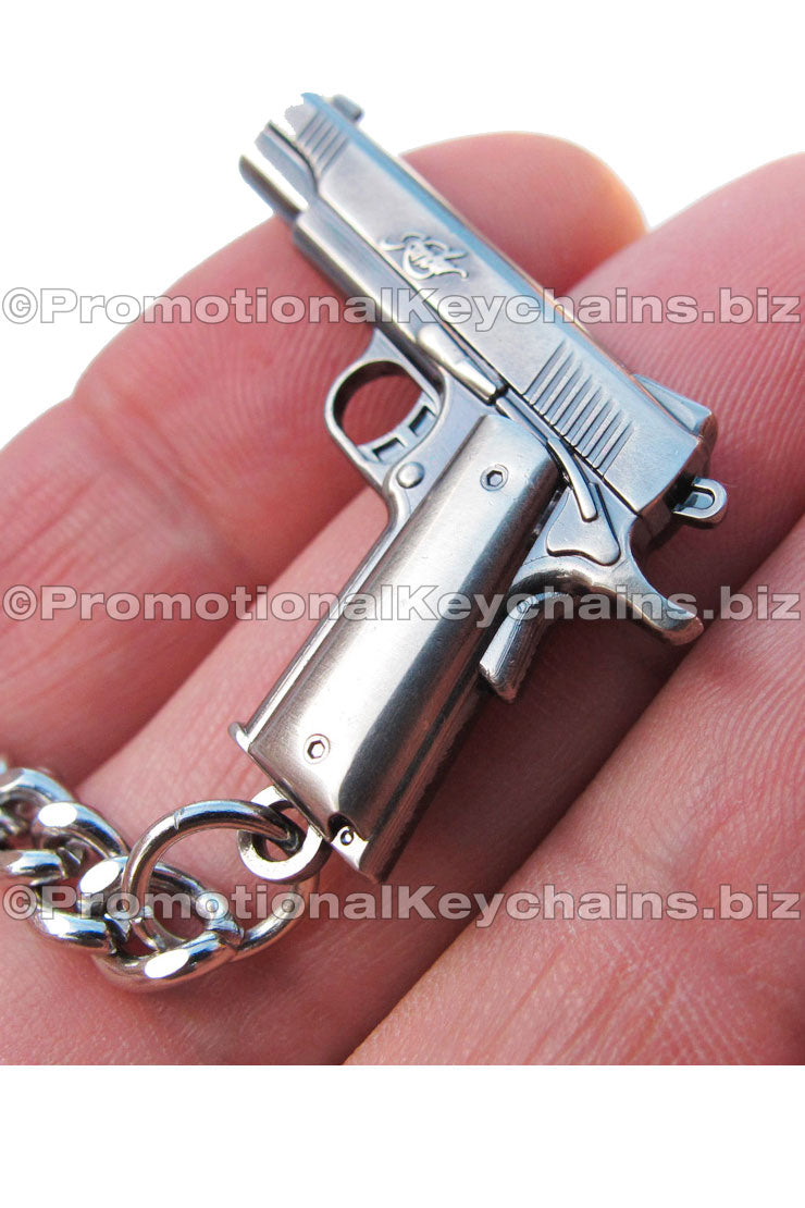 A nickel plated keychain shaped like a small handgun, featuring realistic and intricate details.