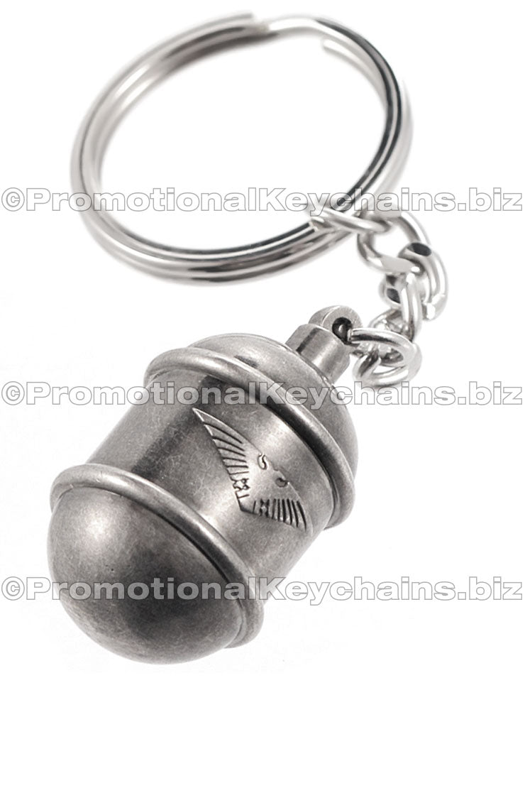 A nickel plated keychain shaped like a grenade with an eagle emblem embossed on the surface.