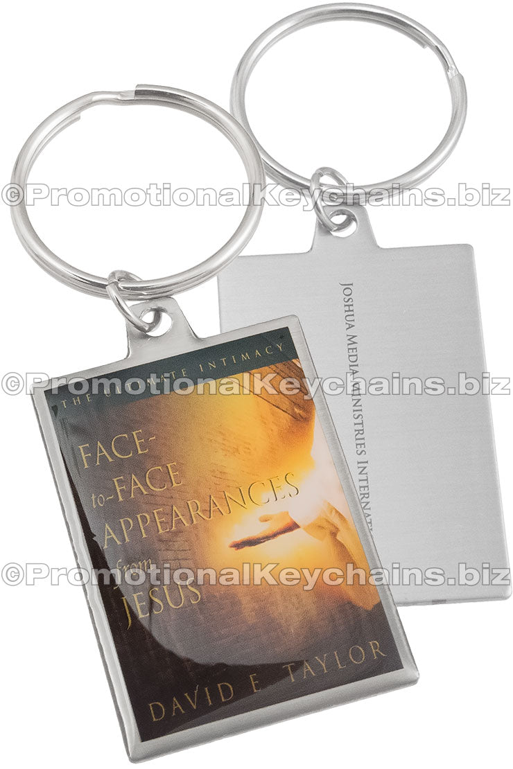 Both sides of a rectangular stainless steel keychain, featuring the book cover of "Face-to-Face Appearances with Jesus" by David E. Taylor and text printed on the smooth back.