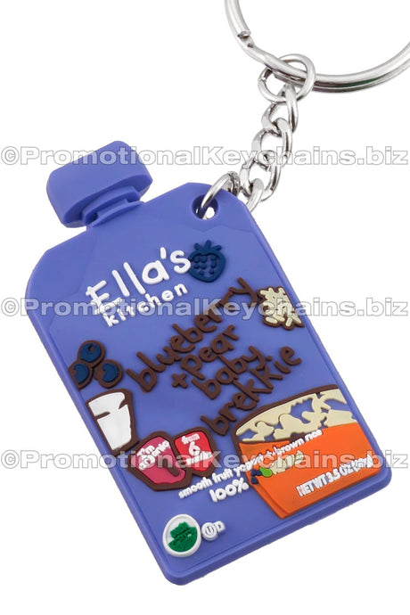 A cornflower blue 3D PVC keychain shaped like a baby food pouch, labeled with "Ella's Kitchen" branding and various cartoon imagery of fruits and grains.