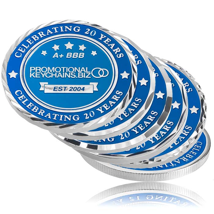 Stack of blue and silver coins with various borders, celebrating 20 years on a white background.