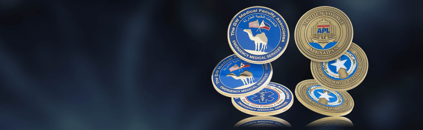 Collection of die struck coins in polished and antiqued platings with blue and gold designs on a dark background