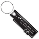 Black trailer shaped keychain with white text and horse design on a white background
