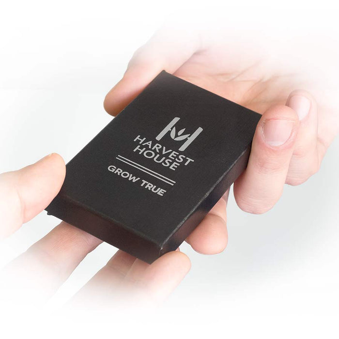 Black box with 'Harvest House' branding held in hands against a white background