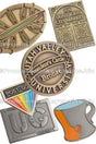 Group of antiqued lapel pins showing different antiqued colors like brass, gold and nickel. Also shows different shapes like circle, rectangles and some custom shapes. 