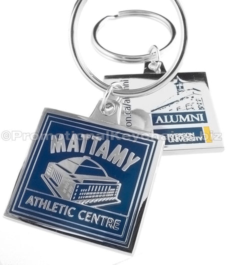 The front and back of a square polished nickel keychain featuring the Mattamy Athletic Centre with a blue enamel background, and an Ryerson University Alumni design on the back side.