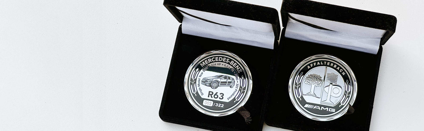 Two silver coins in black cases on a white background