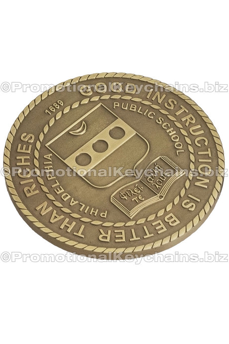 An antiqued brass coaster featuring a Philadelphia Public School logo, surrounded by a rope border.