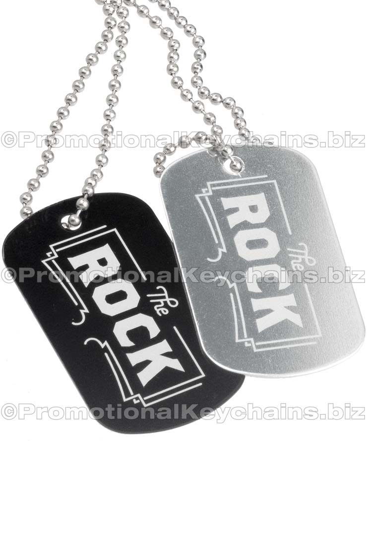Black and silver aluminum dog tags hanging from ball chains. Both with logo  engraved on them. 